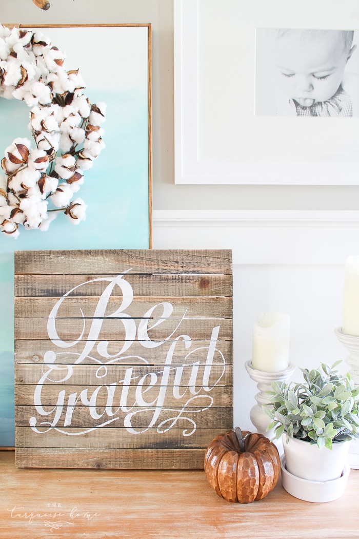 A cozy console table and gallery wall decked out for fall in simple, turquoise and wood toned elements