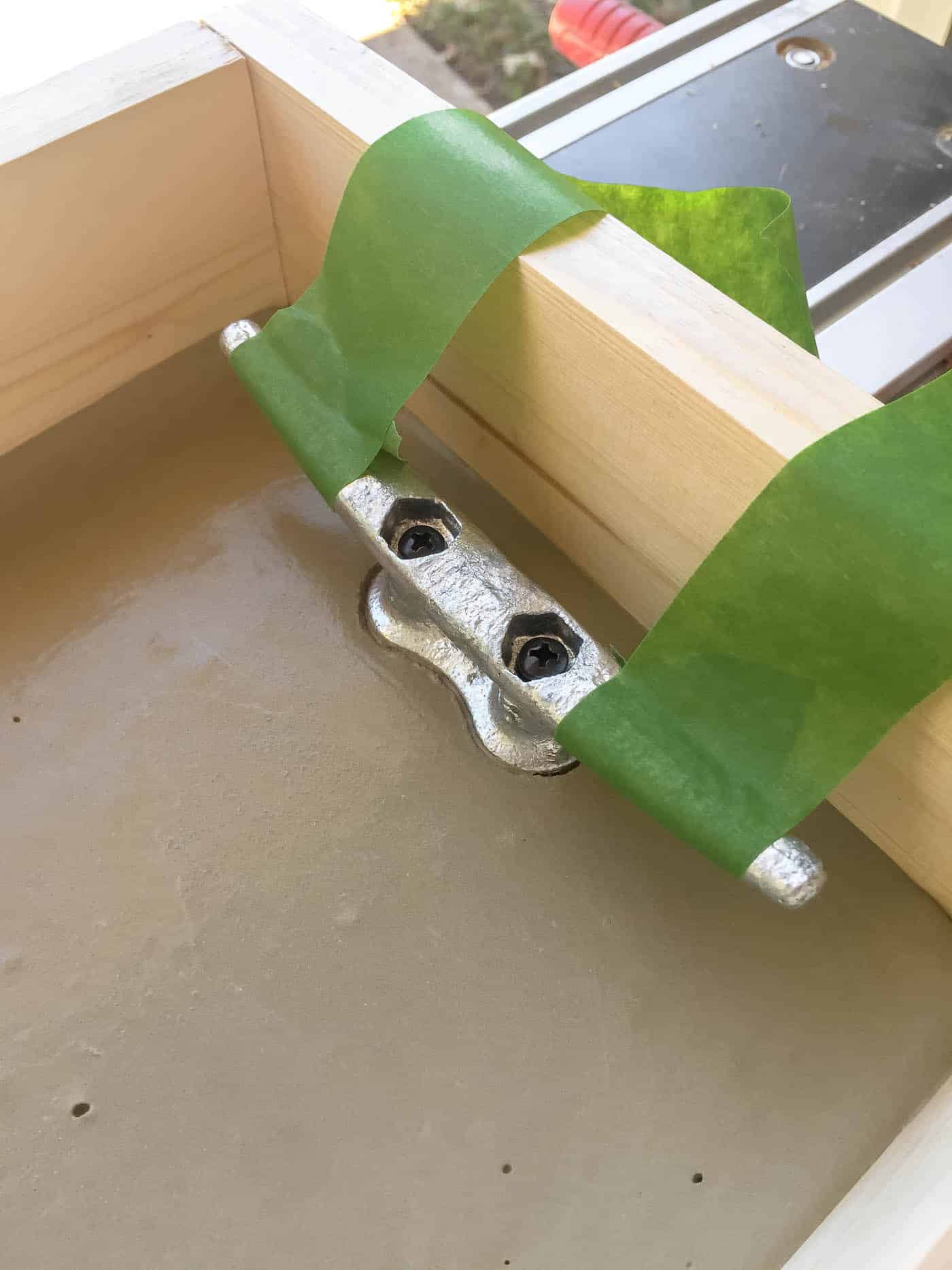 Dock cleat handles in concrete tray held up by painter's tape.