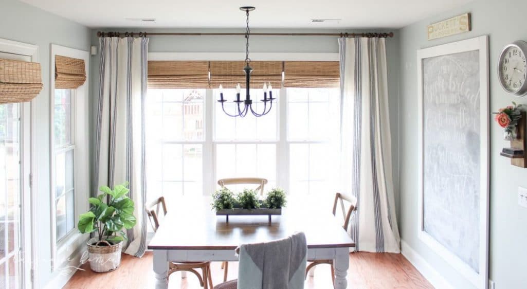Farmhouse kitchen eating area with bamboo shades and Sherwin Williams Sea Salt on the wall.