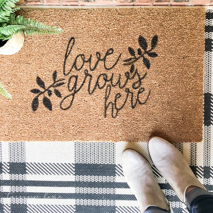 DIY doormat that says "love grows here"