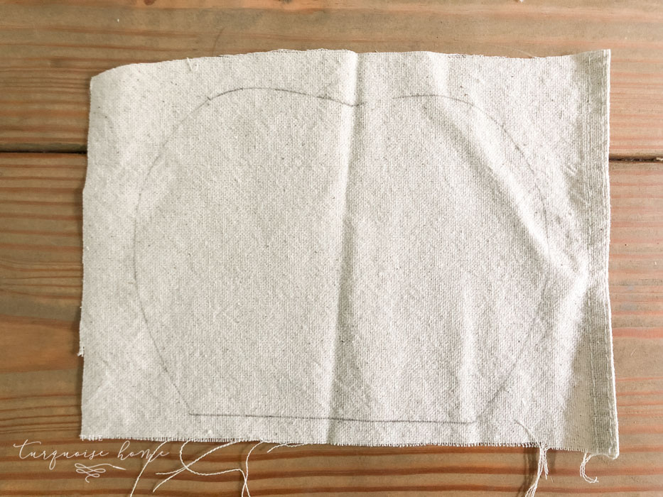 Trace the outline of the wooden pumpkin on the cloth.