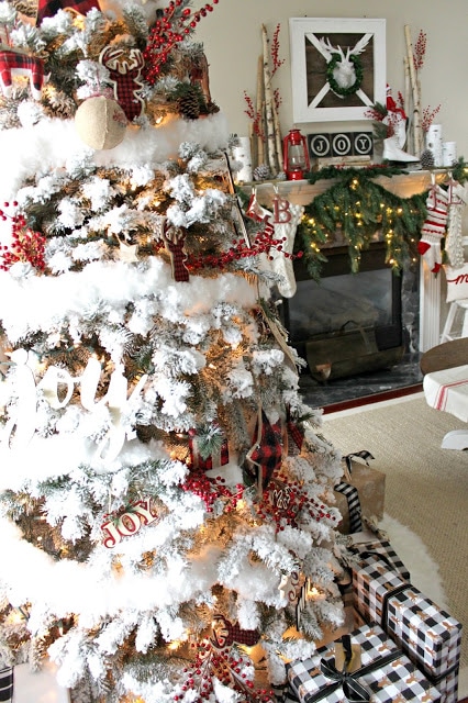 rustic farmhouse flocked Christmas tree with a farmhouse mantel over a fireplace in the living room.