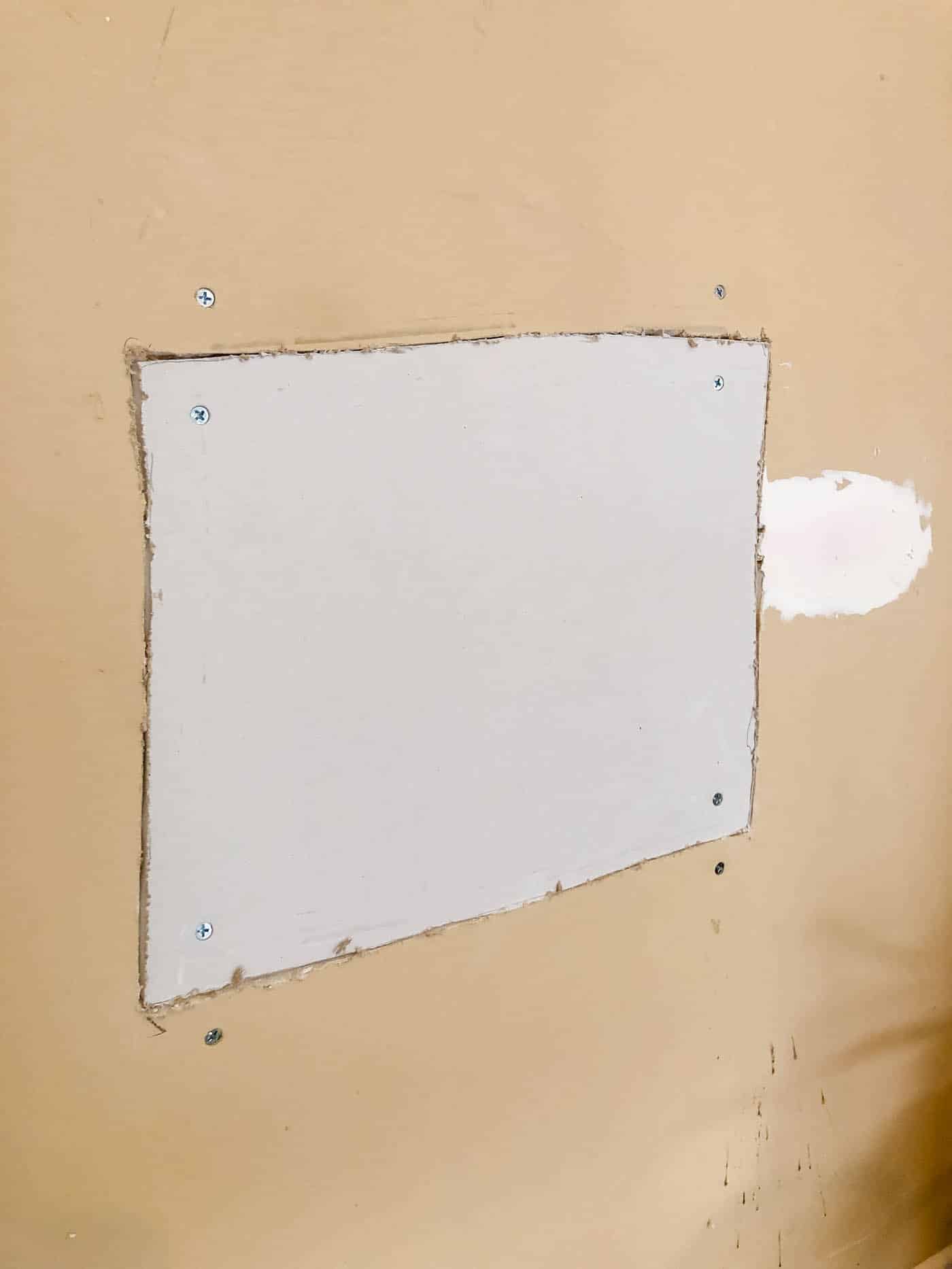attach the new drywall patch with drywall screws into the existing studs.