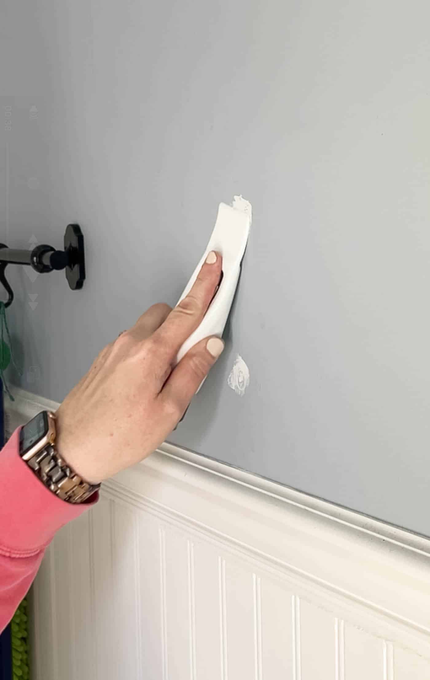 scrape down spackling with putty knife