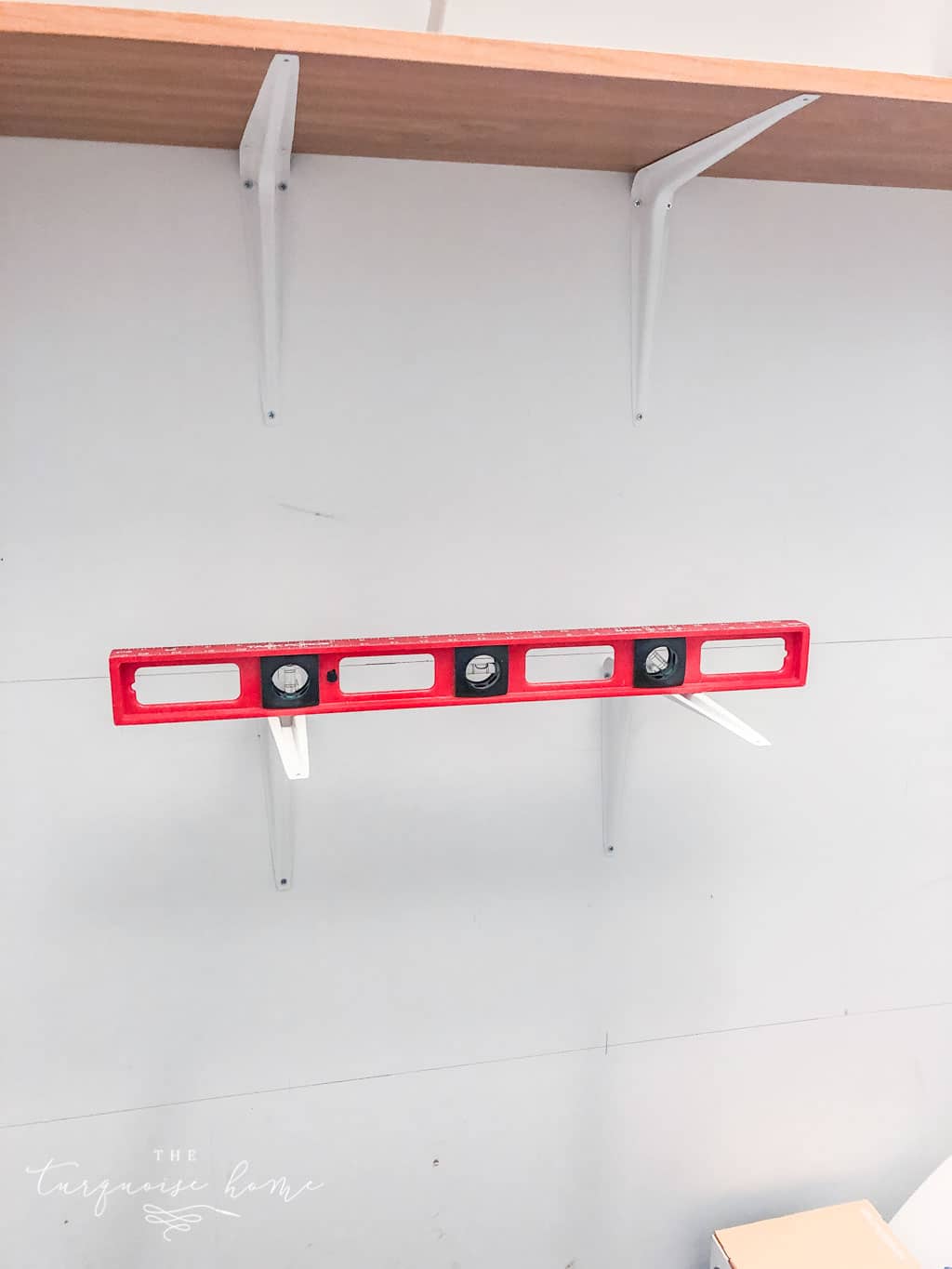 Use a level to keep the brackets straight when installing the pantry shelves.