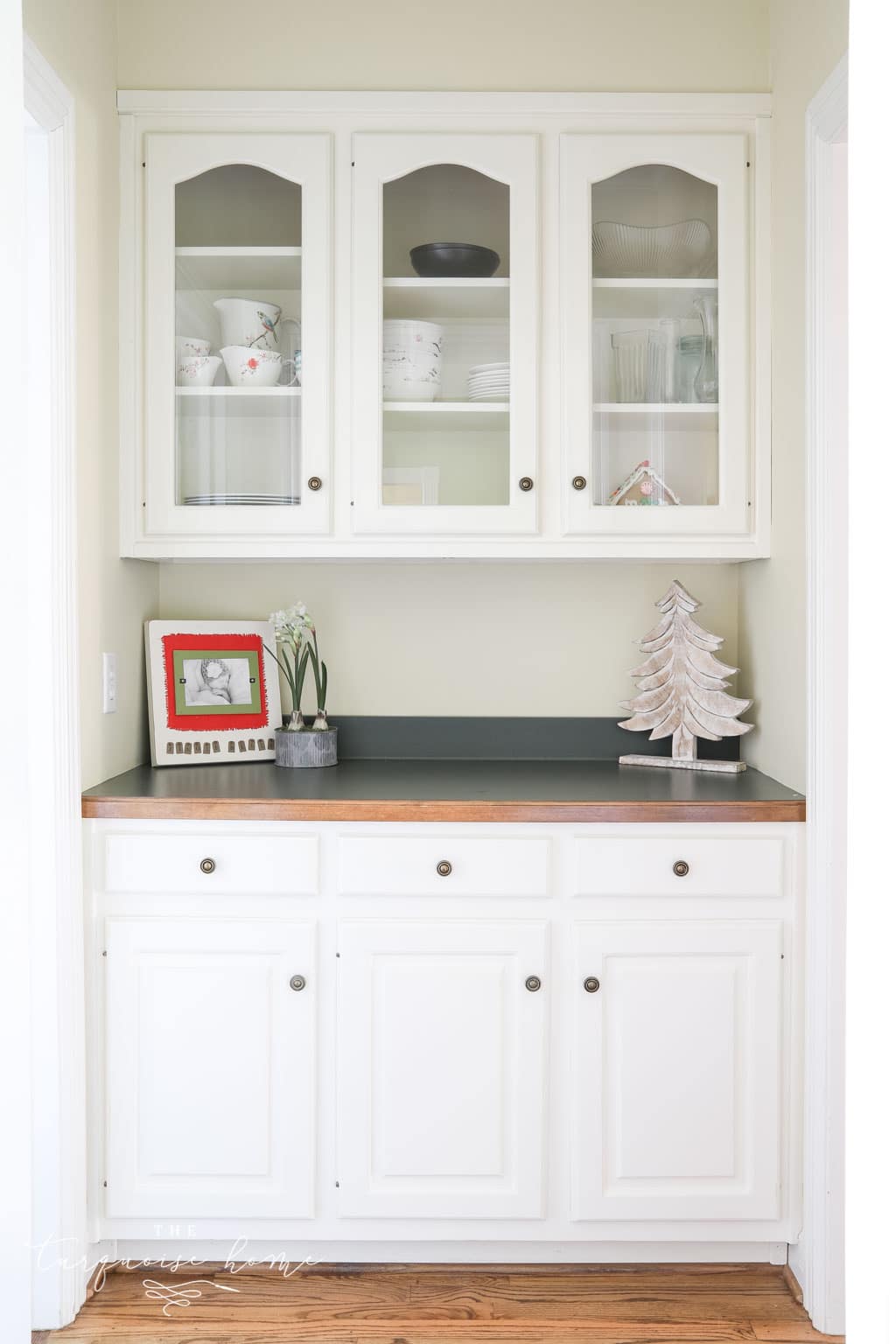 Butler's pantry with glass-front cabinets and hunter green countertops.