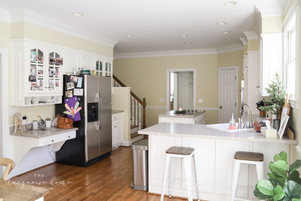 Large kitchen with white cabinets and working island.