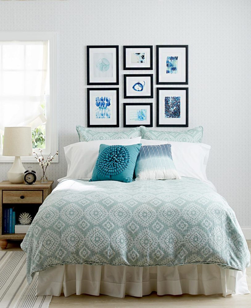 gallery style art hanging above the bed
