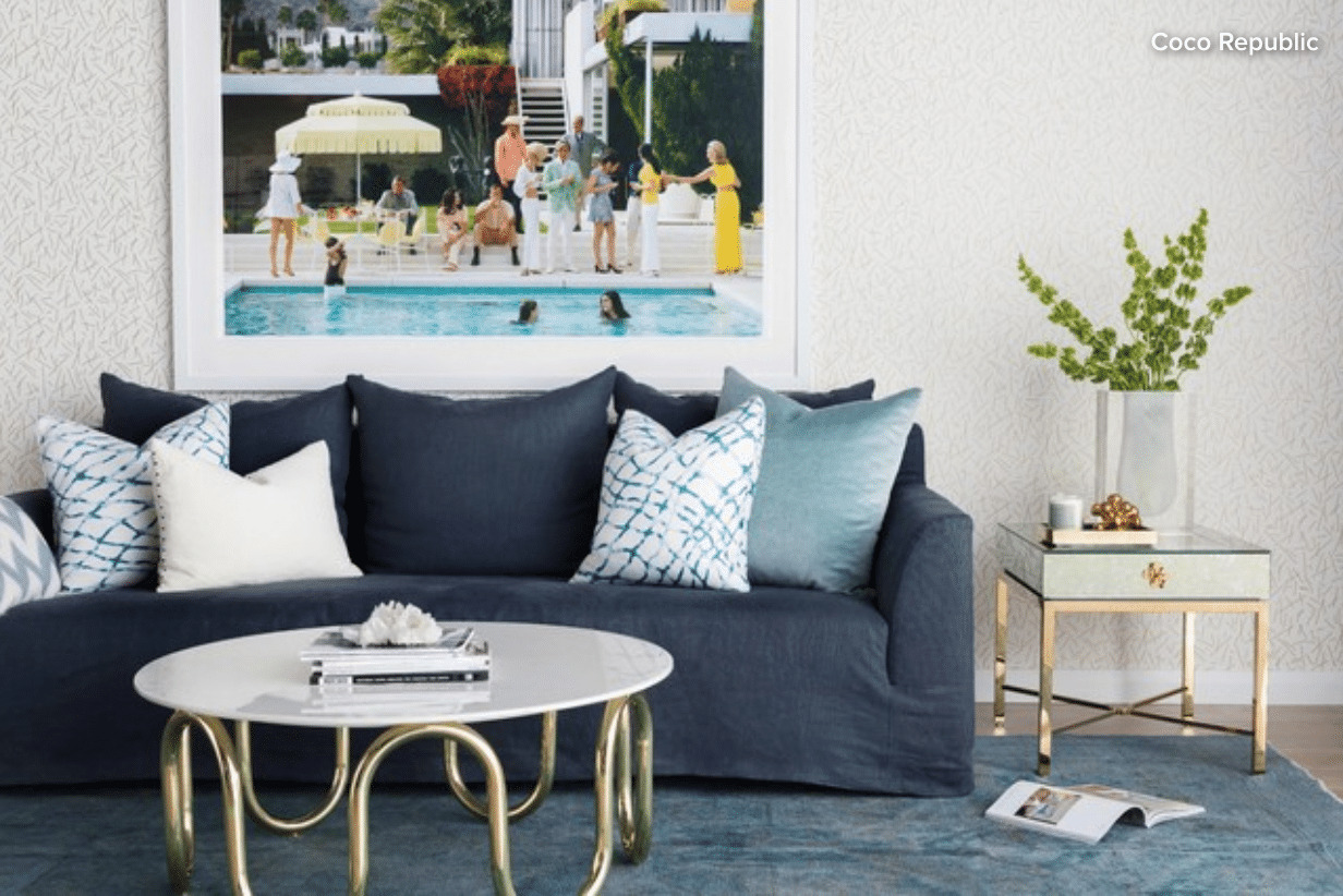 blue couch sitting in a living room with multi colored square throw pillows on it