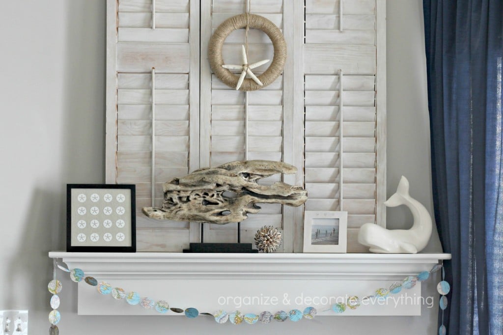 neutral beachy mantel decor with driftwood and framed sand dollars