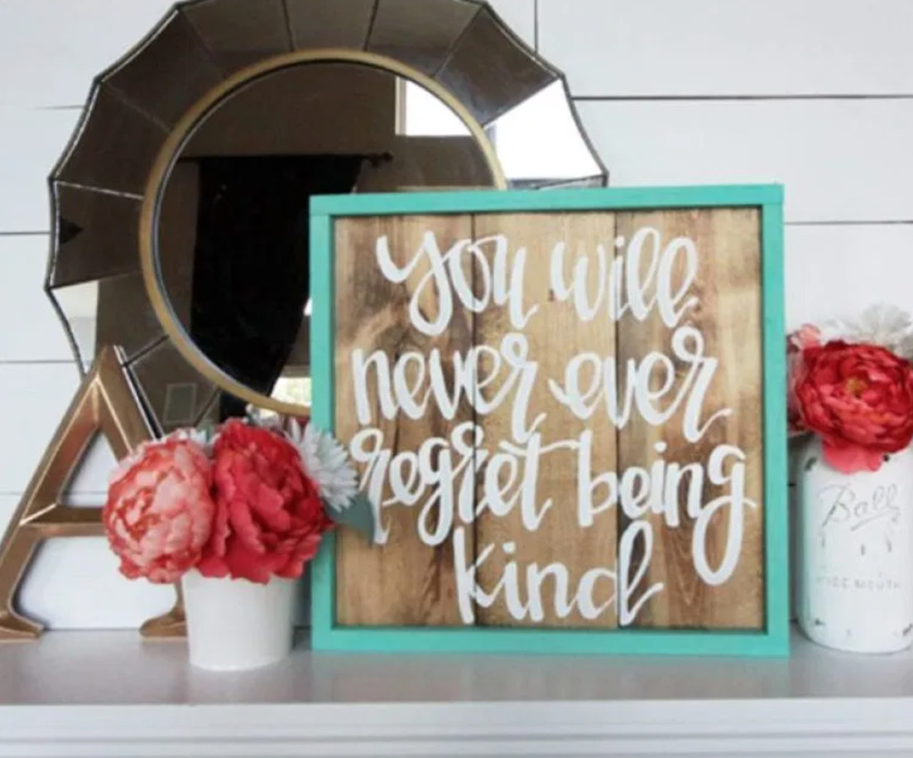 mirror, framed quote, flowers on a fireplace mantel
