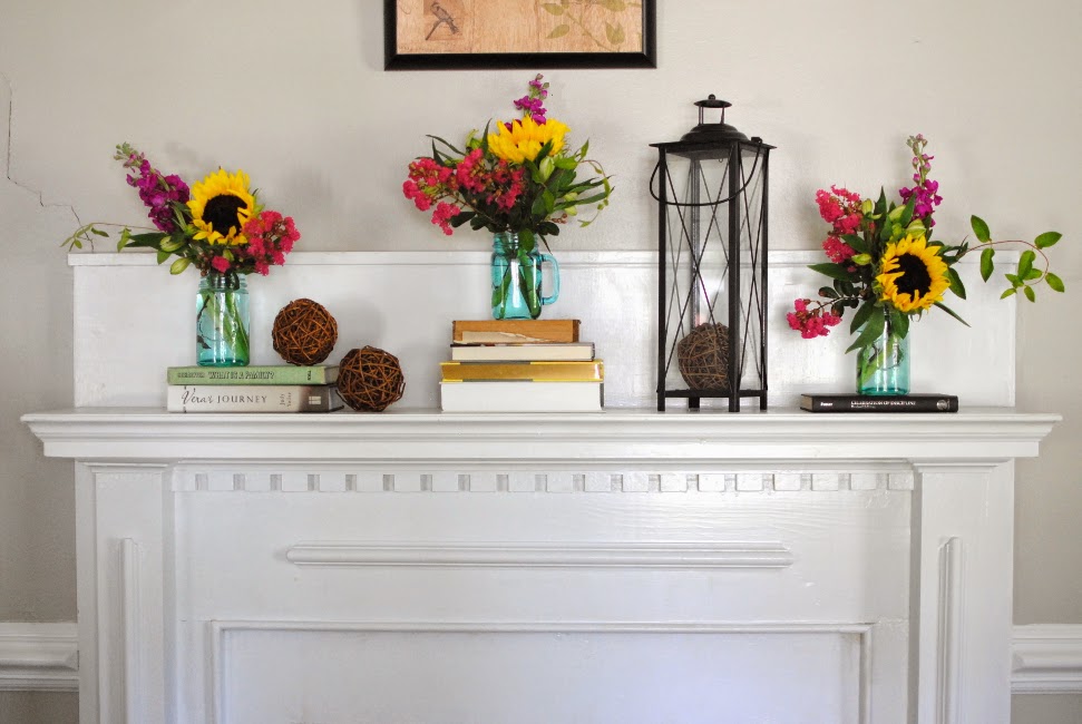 bright pops of color through flowers in mantel decor