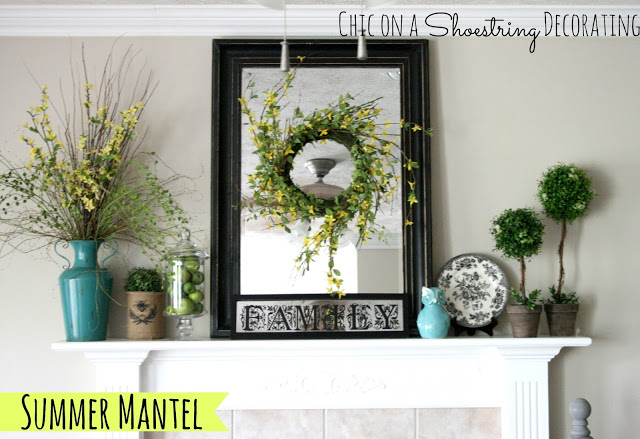 mantel decor with a wreath in front of a mirror, topiaries, and splashes of turquoise