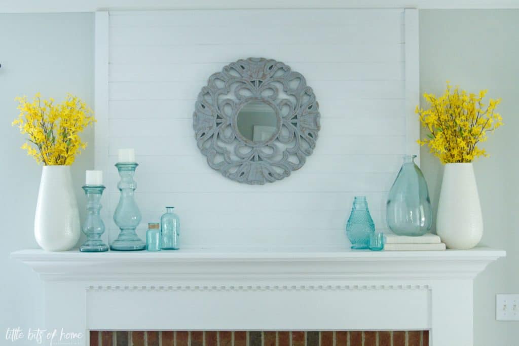 fireplace mantel with statement mirror, blue sea glass and yellow forsythia blooms