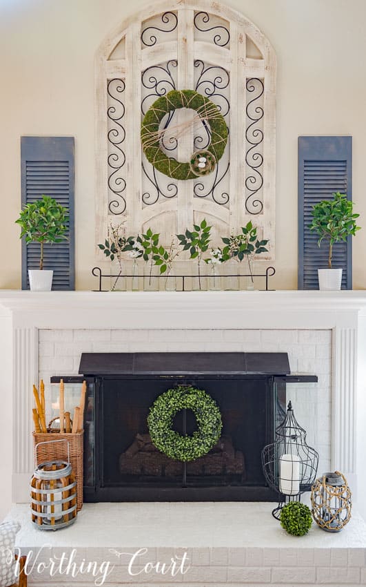 modern farmhouse spring mantel design with boxwood wreaths and other greenery