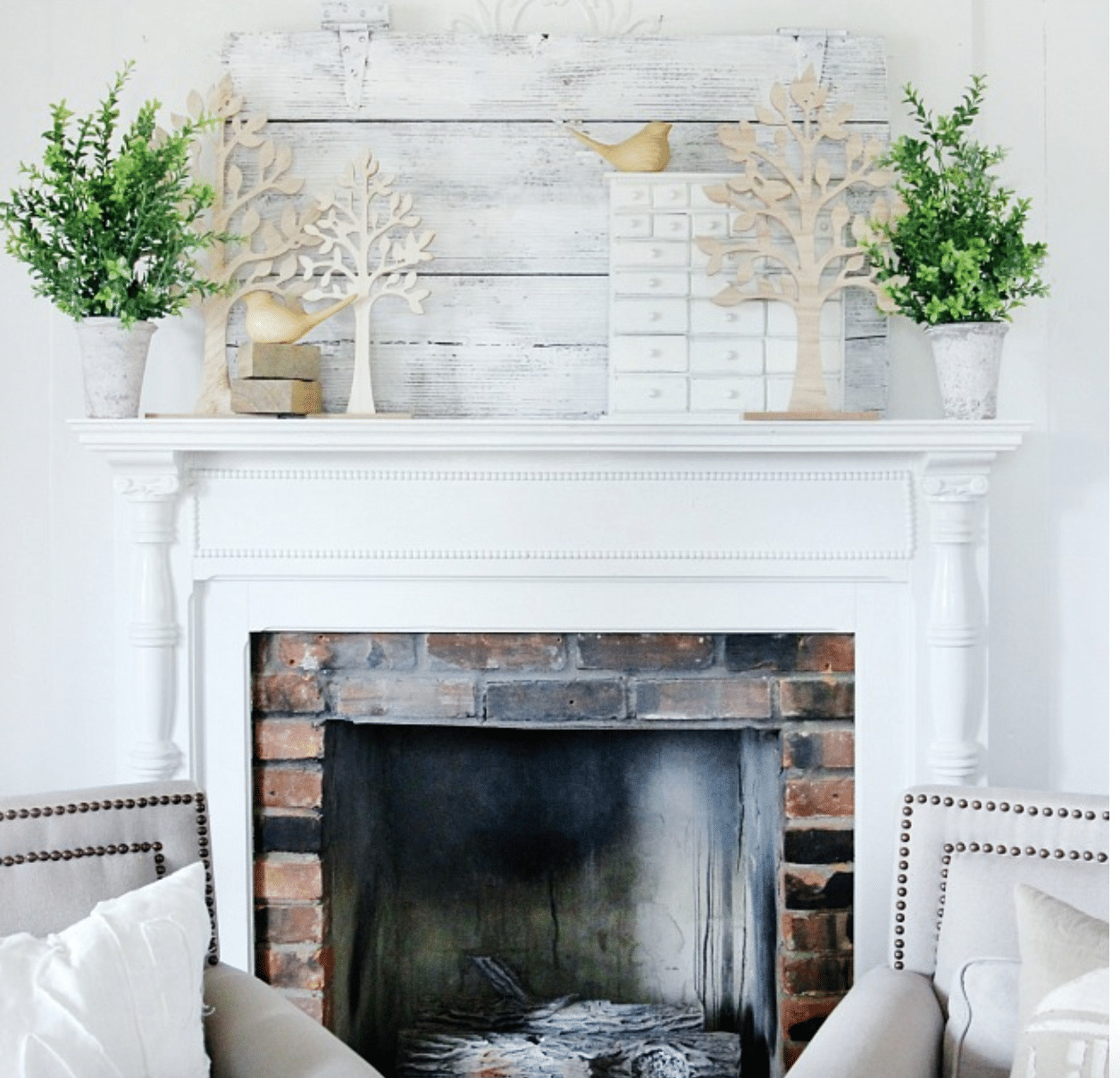 spring mantel decor with tree cut outs, greenery, and bird figurines