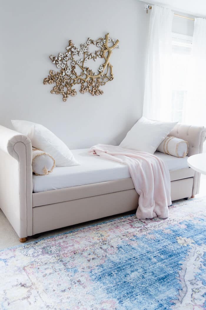 agreeable gray walls behind an upholstered bench with statement wall art above