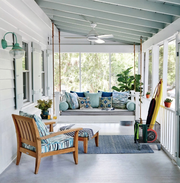 throw pillows decorating the furniture in a screened-in porch