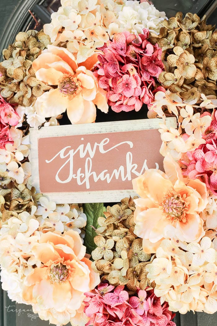 hydrangea wreath in fall colors with sign saying "give thanks".