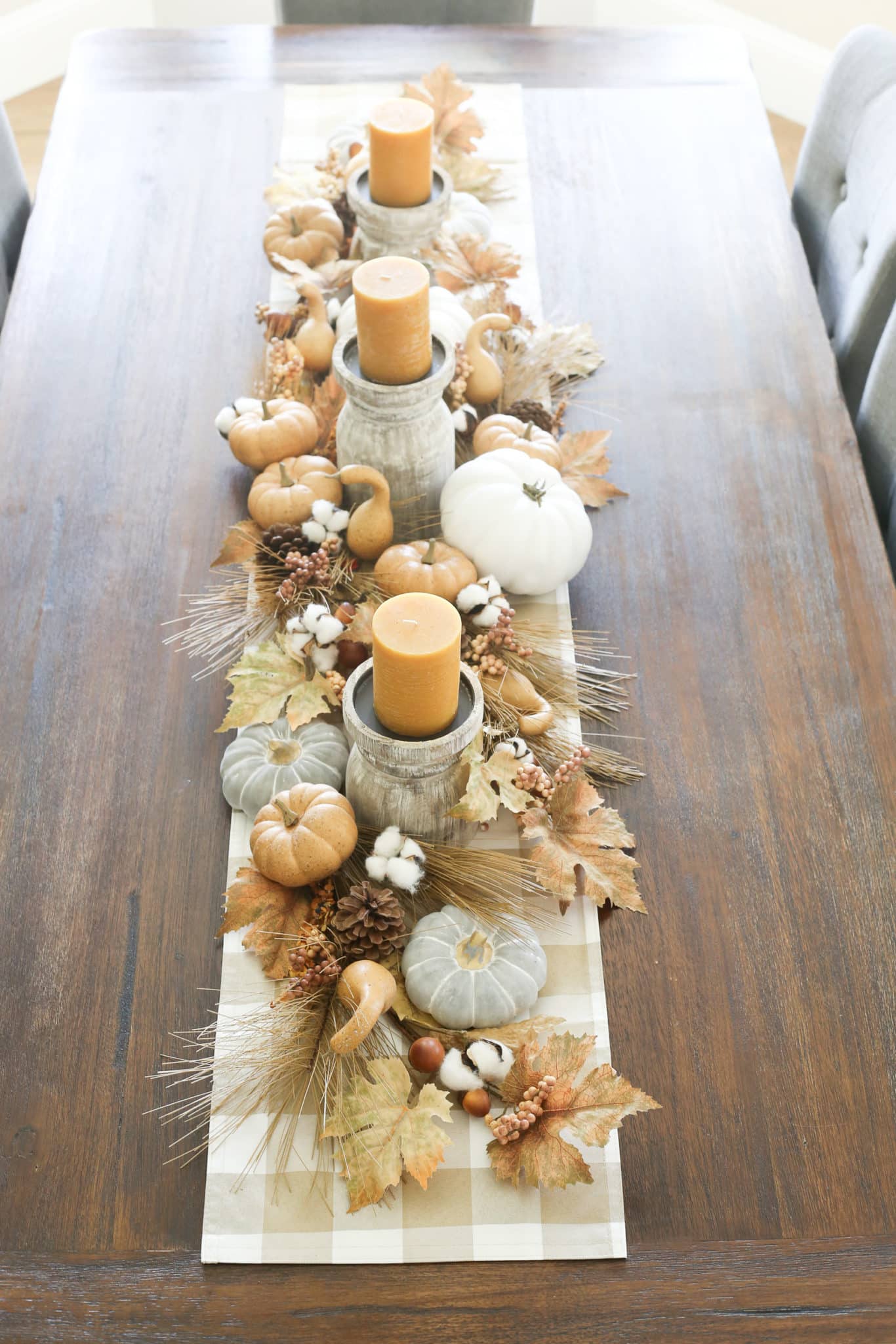 fall tablescape with pumpkins, leaves, and candles.