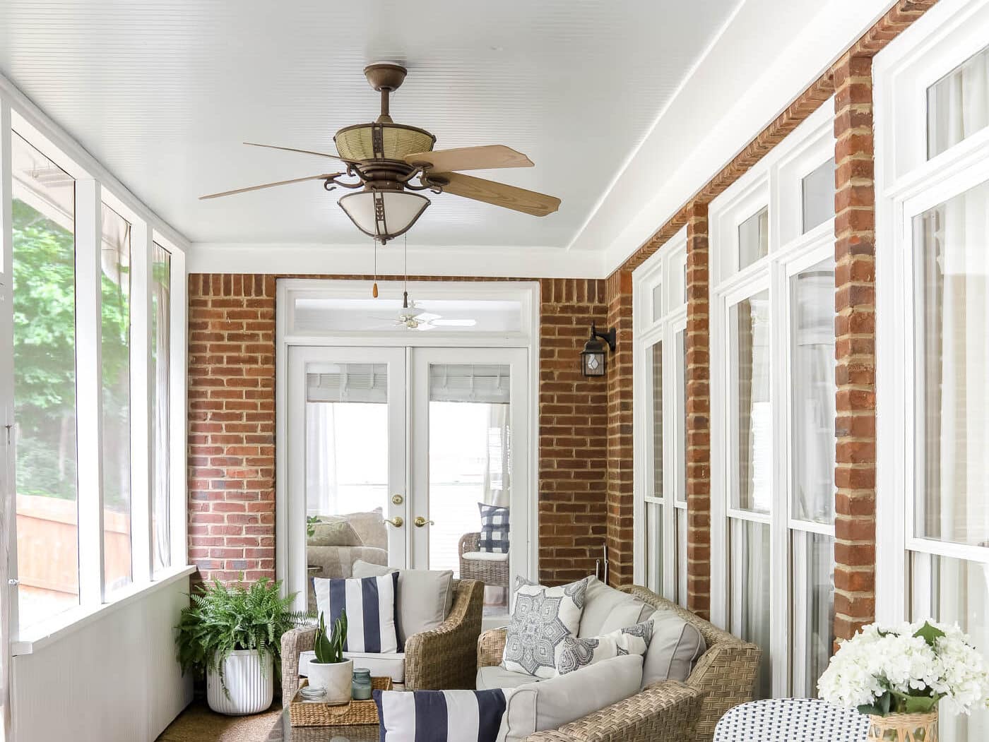 Screened in Porch Ideas with wicker patio furniture and haint blue porch ceiling.