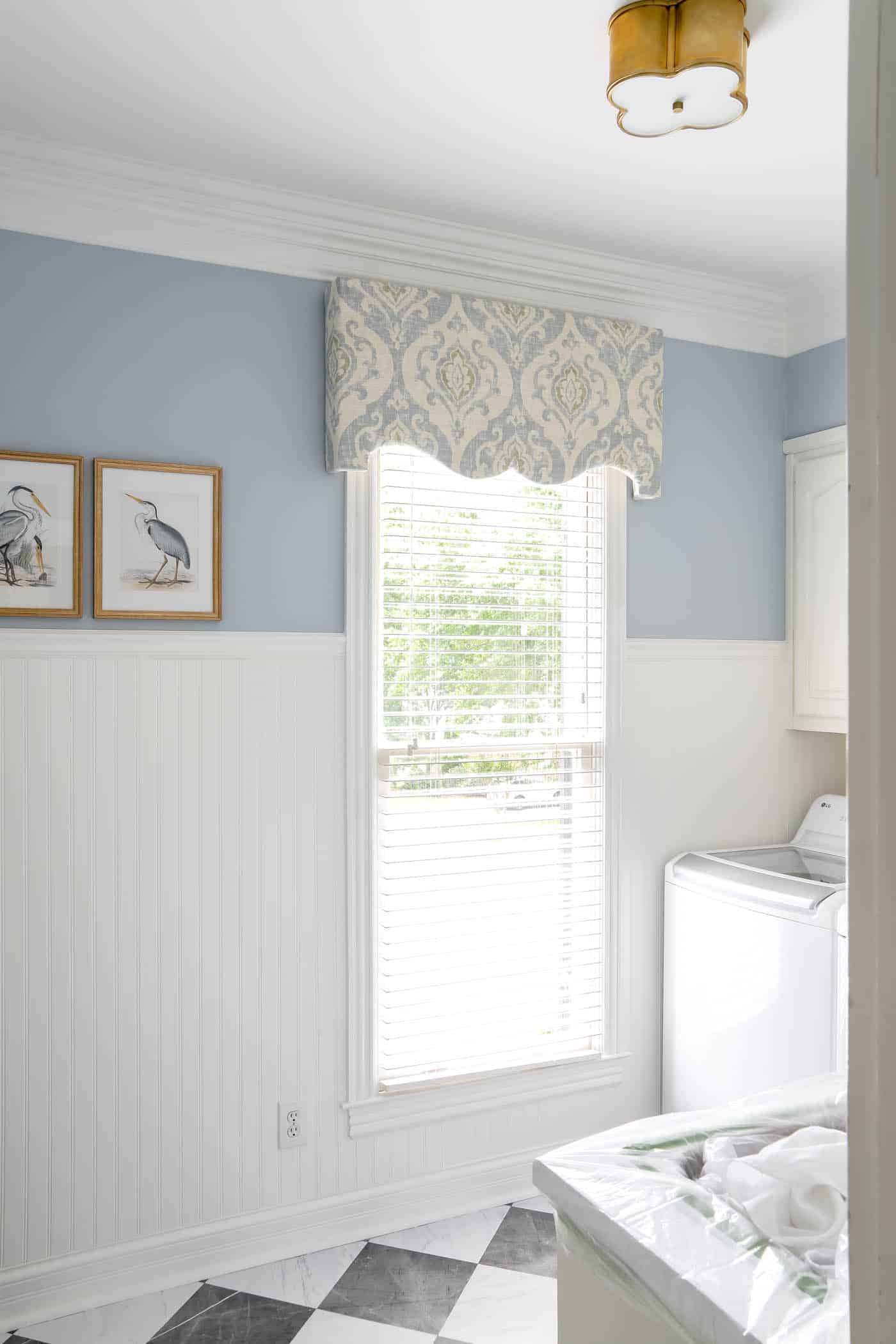 Laundry room with blue walls and white beadboard.