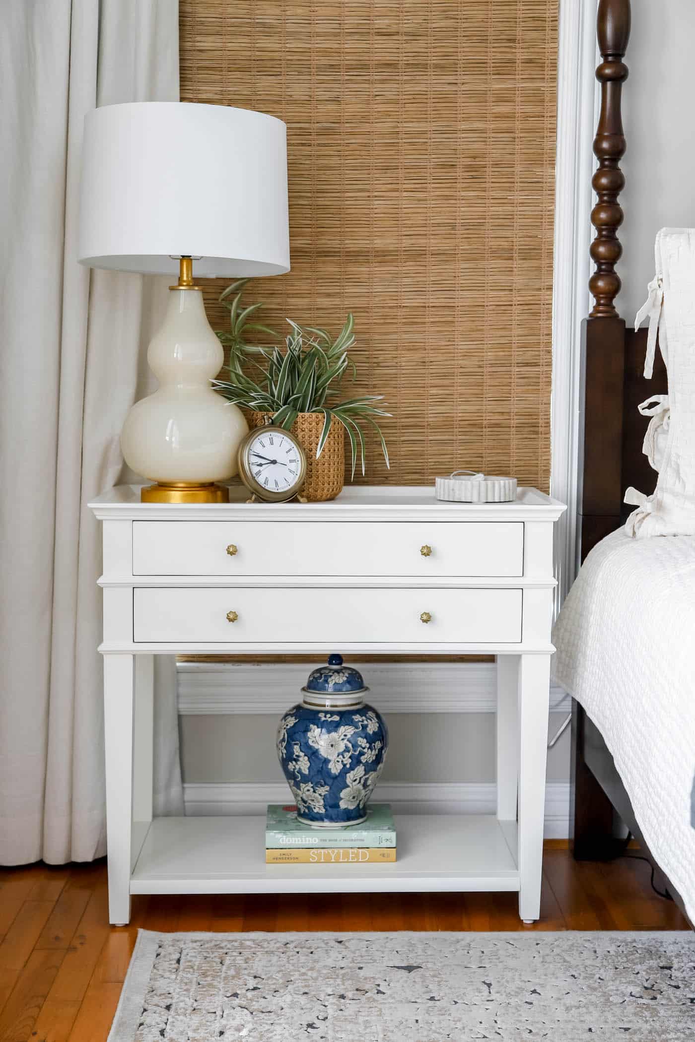 White nightstand with cream lamp and chinoiserie ginger jar.