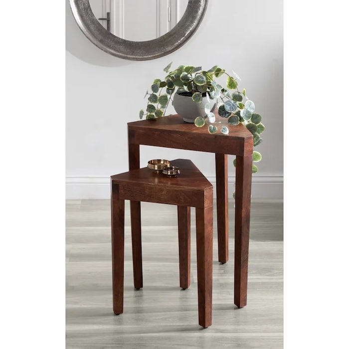 nesting tables for a corner of a room with a plant on it.