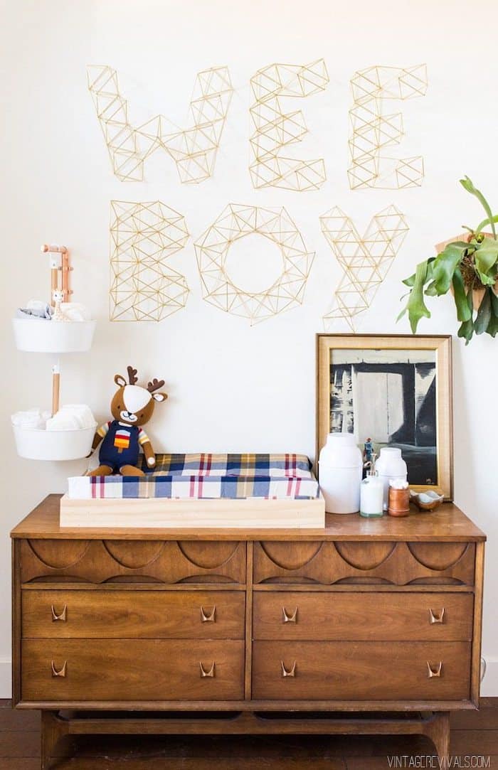 Boy's nursery with Sherwin Williams Alabaster wall color and "wee boy" wall art over a wood dresser with a changing pad.