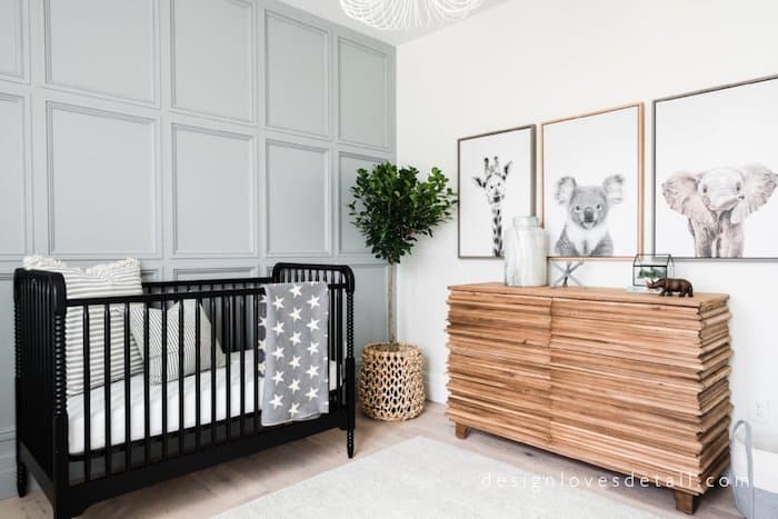 Wall moulding in nusery painted Boothbay Gray and animal photos on opposite wall with a black crib.