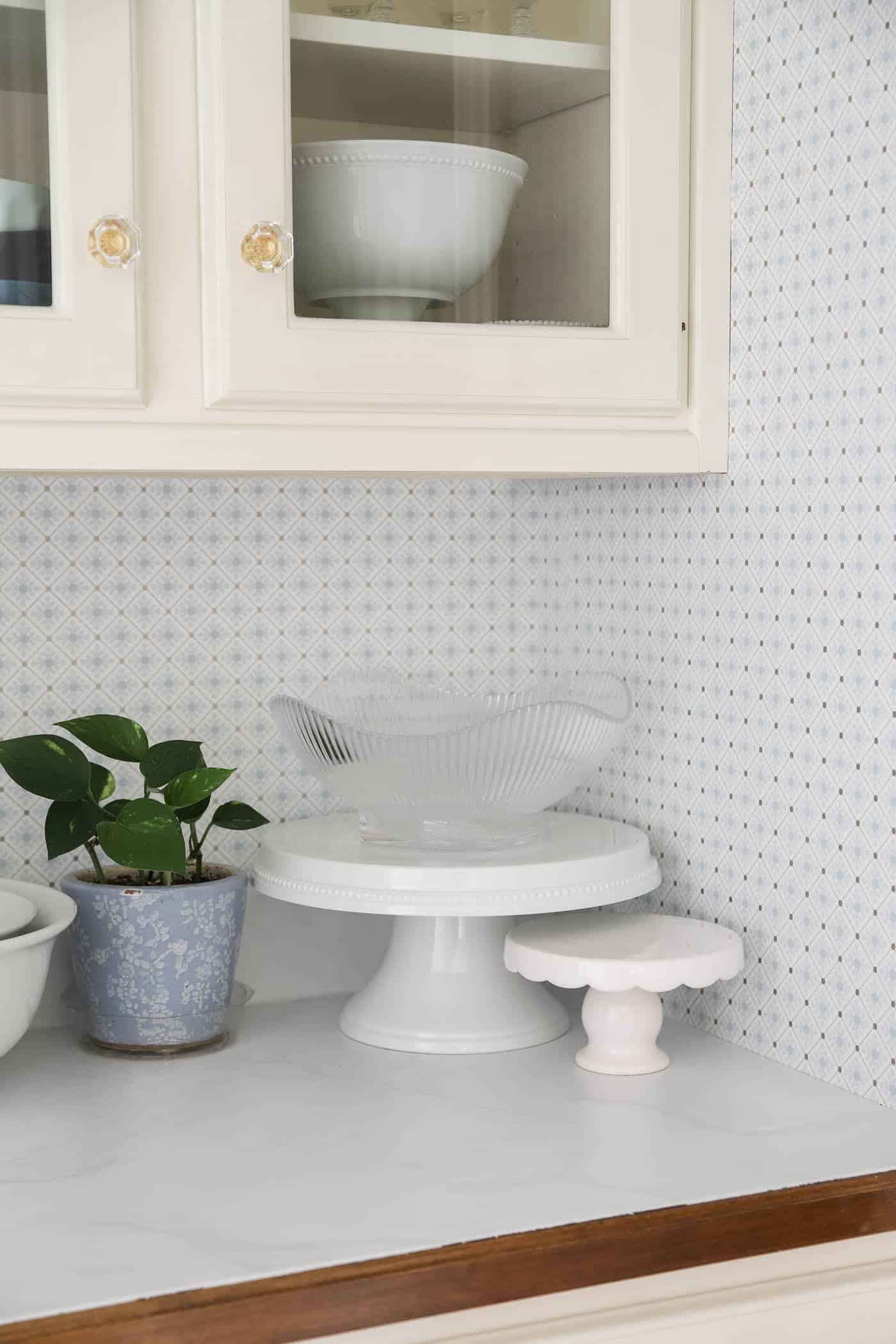 marble countertops with blue and white goemetric wallpaper on the walls.