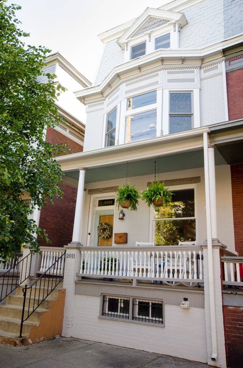 Row home with blue painted porch ceiling in Benjamin Moore Wythe Blue.