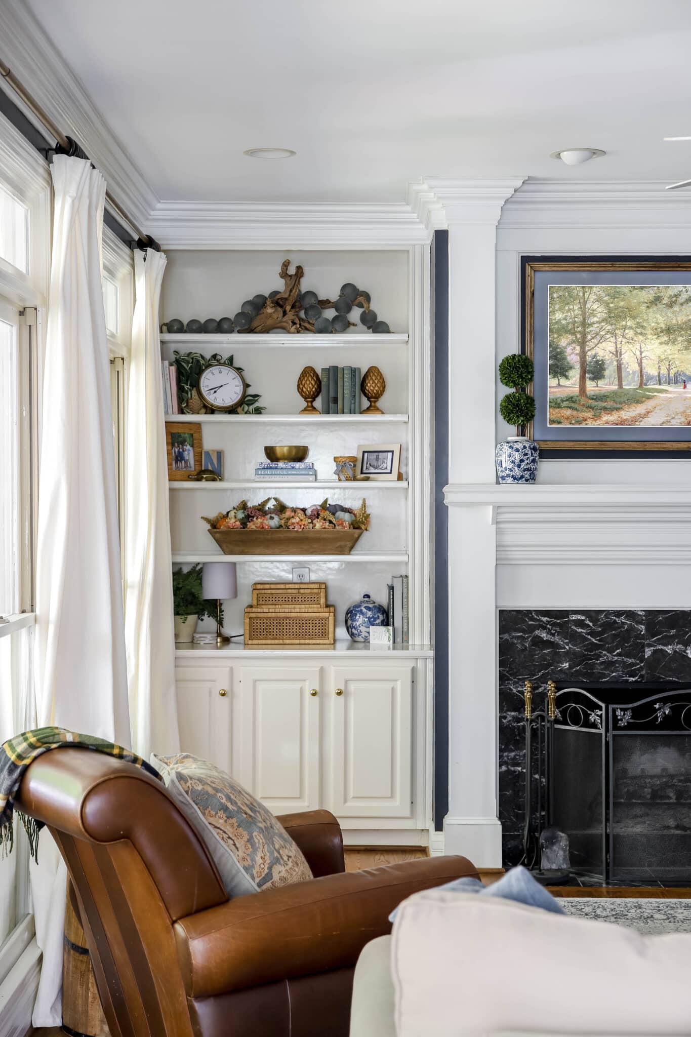 fall living room bookshelves with Fall dough bowl filled with pumpkins and colorful hydrangeas