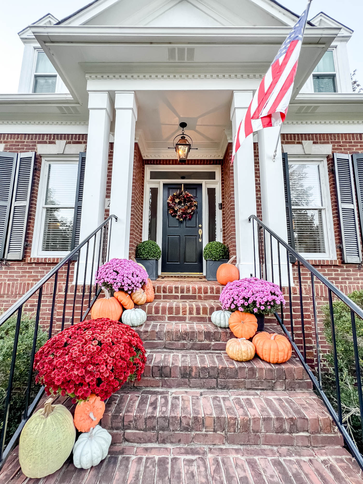 long shot of front porch with realistic fake pumpkins