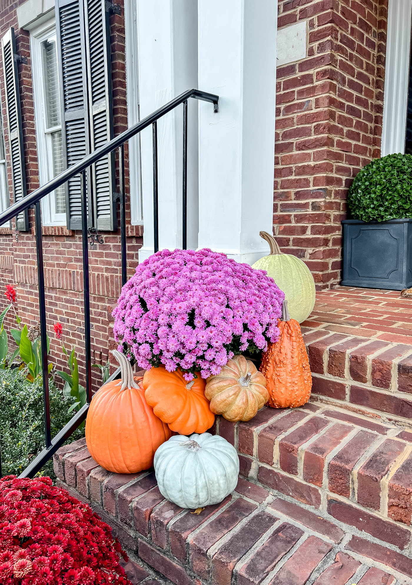 realistic fake pumpkins on front porch steps.