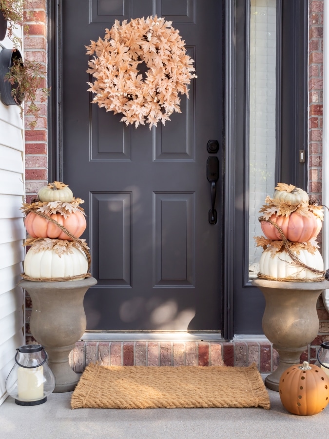 neutral gray door with pumpkin topiaries.