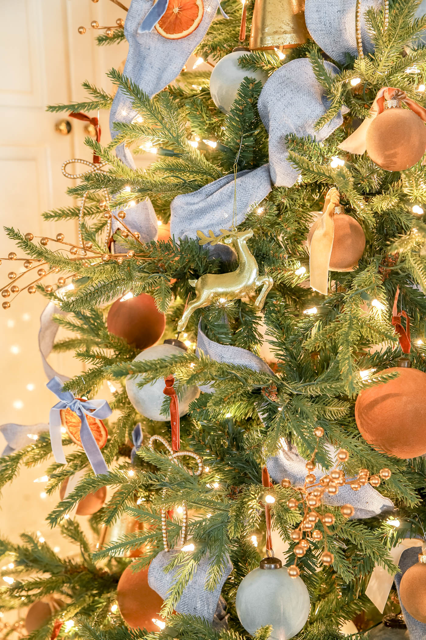 blue ribbon on a pre=lit christmas tree