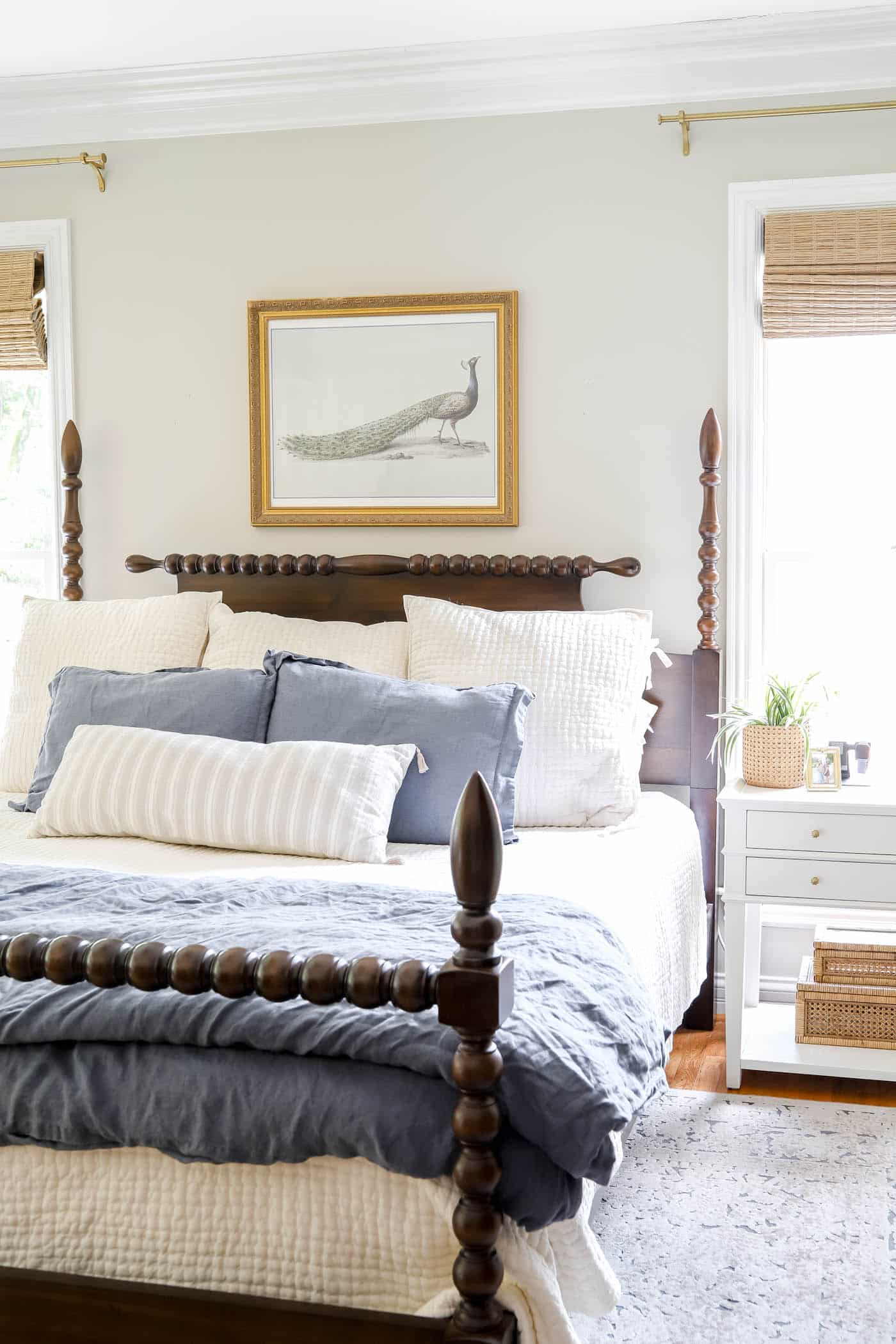 DIY peacock art over a wood headboard with gray walls.
