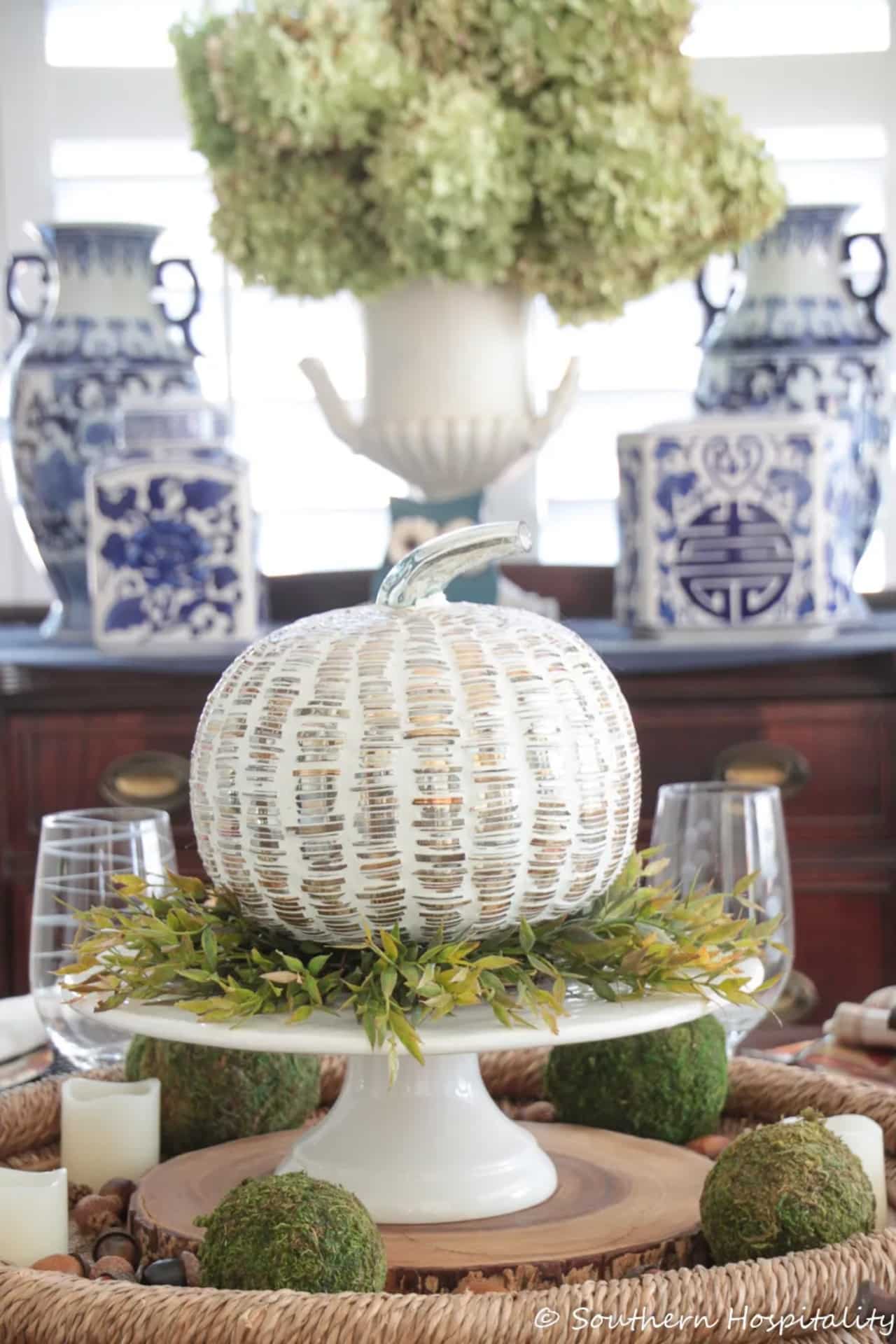 Thanksgiving table with pumpkin decor in the middle.