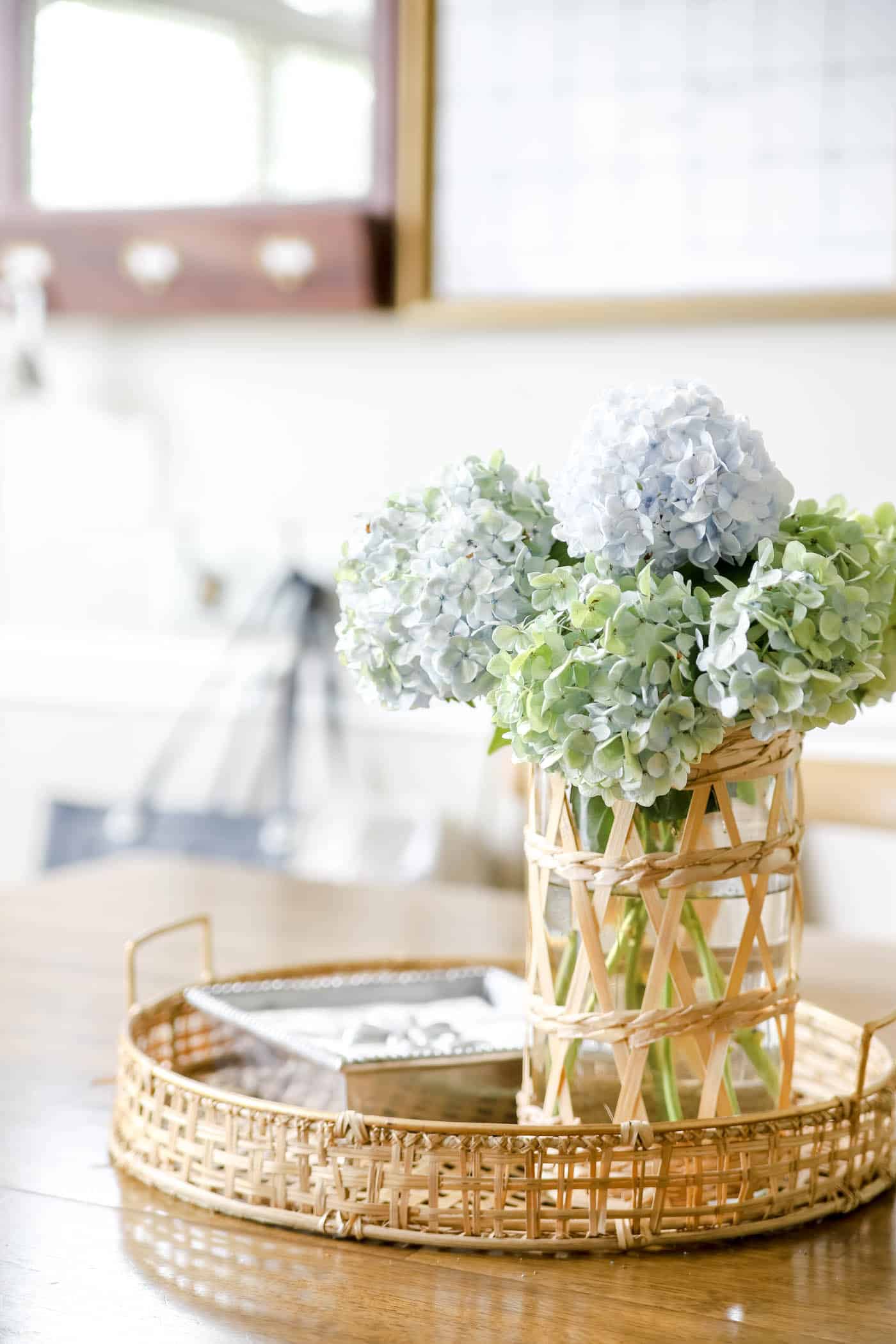 blue and green hydrangeas in a vase on a wood table