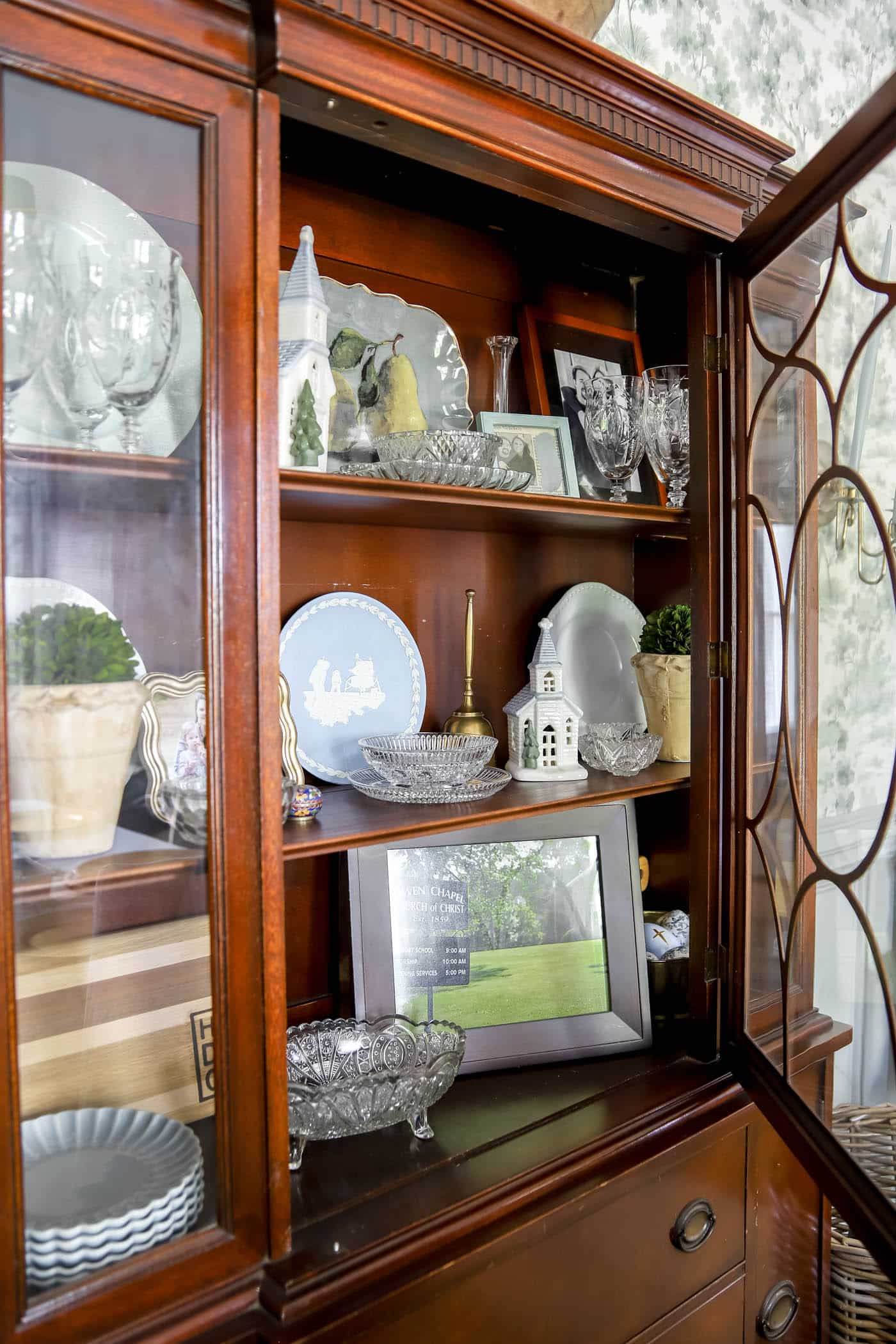 China cabinet with silver and glass inherited pieces.