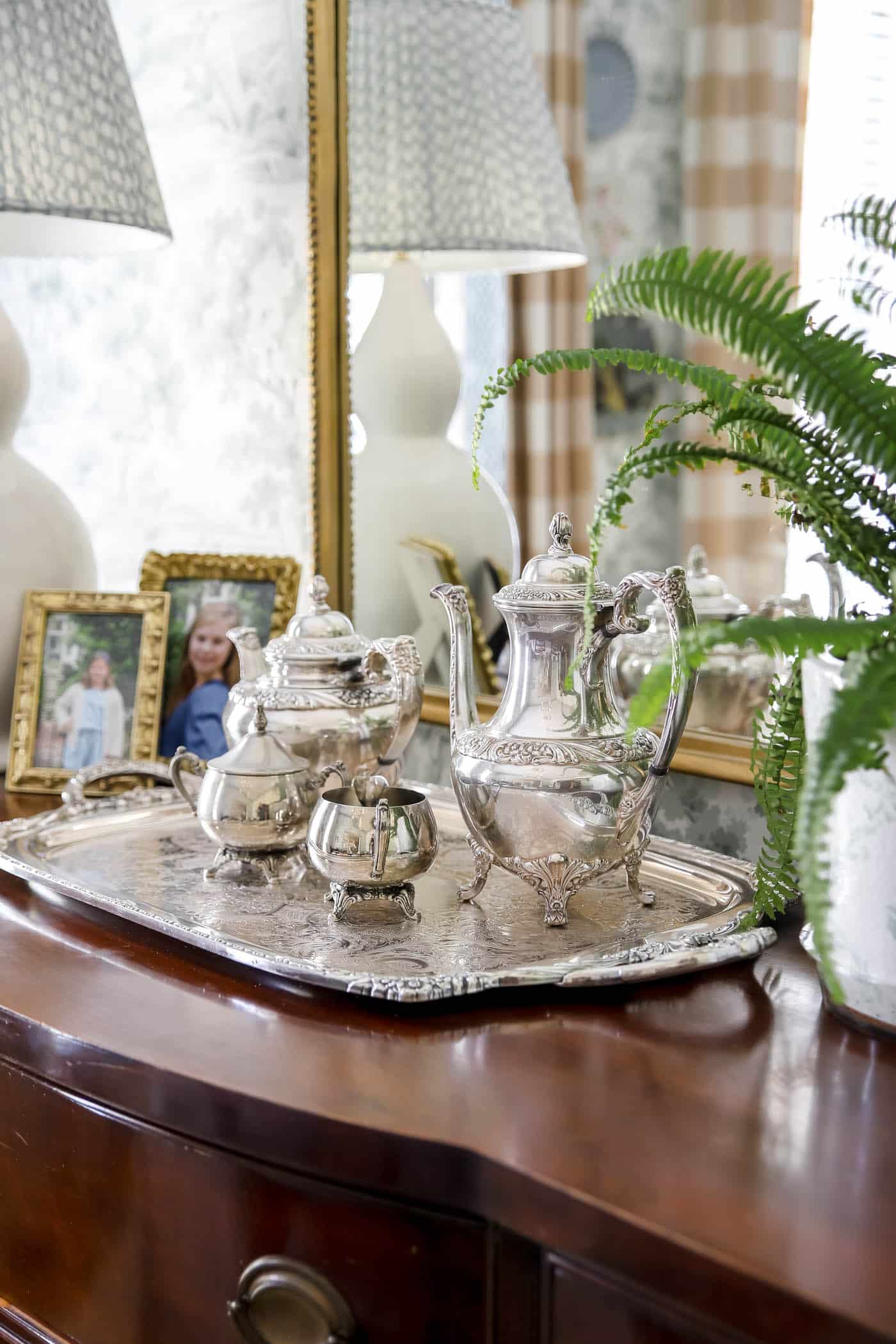 silver coffee and tea with a silver tray on a wood buffet