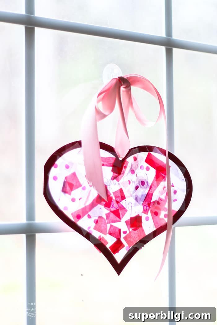 We used this in my daughter's Kindergarten class party! The kids LOVED it! | DIY Tissue Paper Sun Catcher Valentine's Kid Craft
