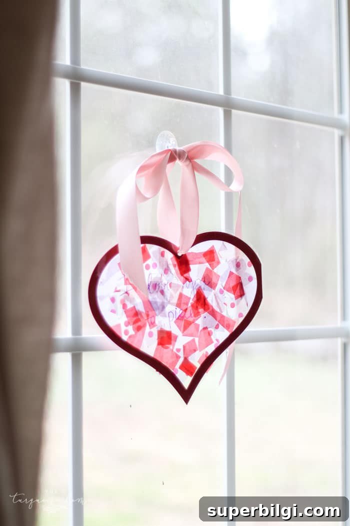 Finished tissue paper heart suncatcher hanging in a window