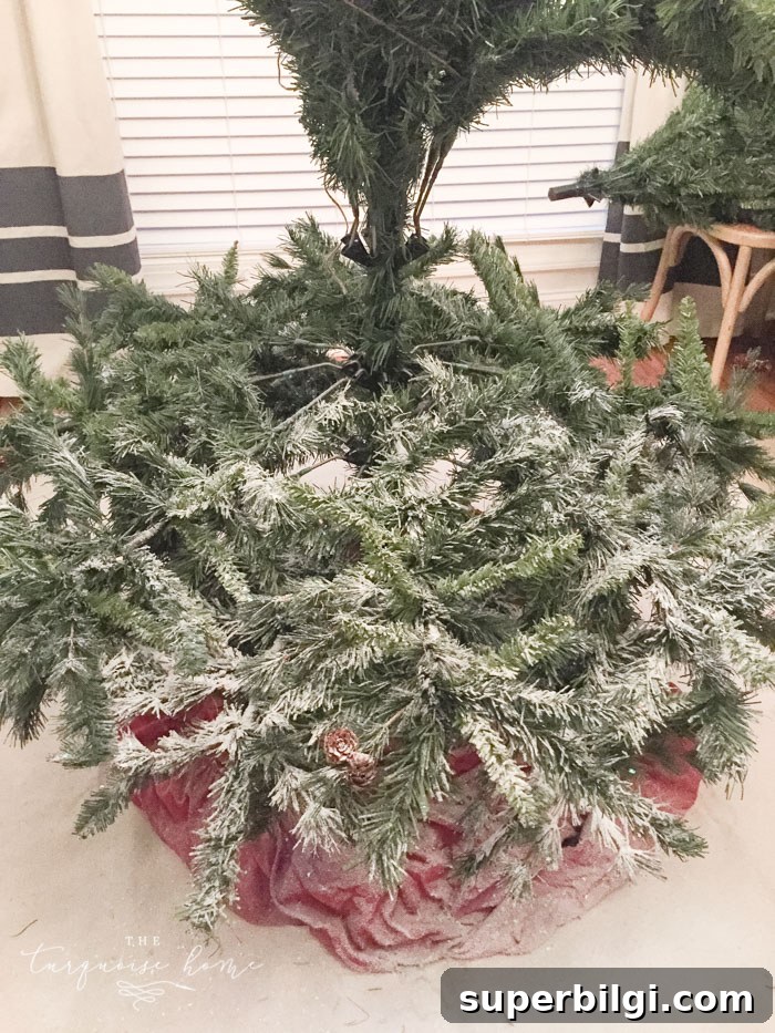 How to Flock a Christmas Tree: DIY Snowy Tree Tutorial 5 Flock the tree as you go to reach the branches inside the tree.
