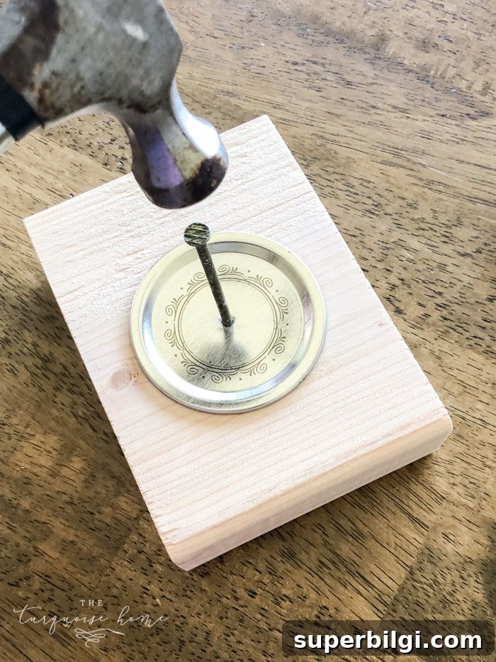 How to Make a Mason Jar Snow Globe Ornament for Christmas 5 Hammer nail into center of lid to make hanger