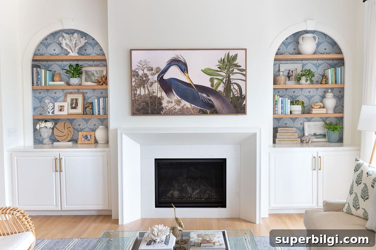 Bookshelf Styling Ideas to Transform Your Bookcase 19 styled bookcases flanking a modern white fireplace with a TV art above it.