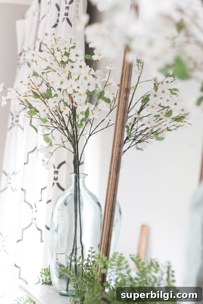 A Simple Summer Mantel -->> wood mirror, glass vase, dogwood stems and locust garland
