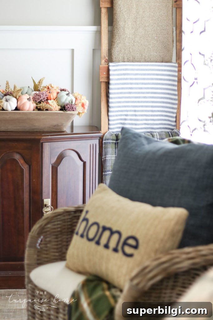 Neutral Fall Mantel Ideas for a Cozy, Timeless Look 2 Fall pumpkin centerpiece with home pillow and blanket ladder.