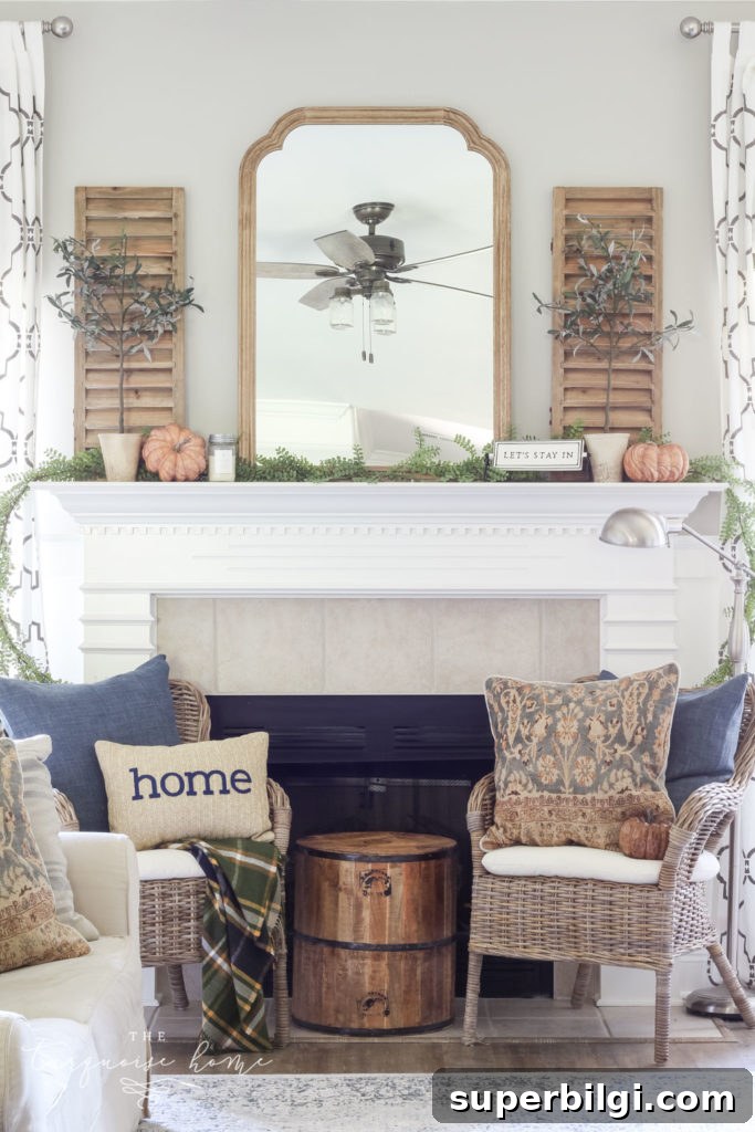 Neutral Fall Mantel Ideas for a Cozy, Timeless Look 5 Beautiful neutral fall mantel with blues and browns and beautiful fall greenery.